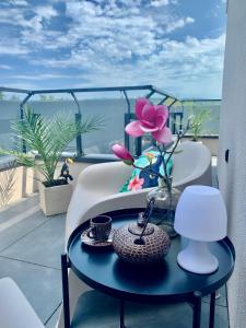 Madagascar Apartman Keszthely في كيزتيلي: طاولة مع زهرة أرجوانية على شرفة