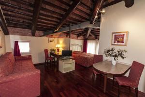 Residence Bertolini في بادوفا: غرفة معيشة مع سرير وطاولة مع لاب توب