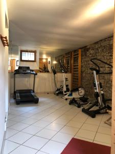 una habitación con un gimnasio con cintas de correr y máquinas en Appartement avec rez de jardin, Sauna et Hamam, en Villard-de-Lans