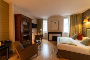 a hotel room with a bed and a chair at Hôtel Le Griffon d'Or in Bourg-en-Bresse