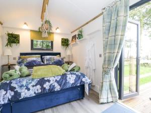 a bedroom with a blue bed and a window at High Rigg Shepherd's Sunset in Carlisle