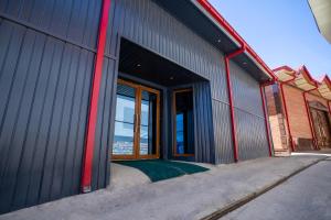 a large metal building with a large door and windows at Heartland Hostel Samarkand in Samarkand