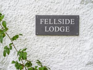 a sign on a wall with the word satisfied lodge at Fellside Lodge in Windermere