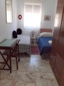 een slaapkamer met 2 bedden, een tafel en een raam bij CASA DEGLI OLEANDRI in Carlentini