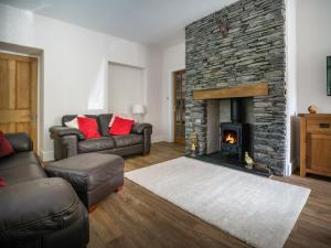 a living room with a couch and a fireplace at Fellside Lodge in Windermere