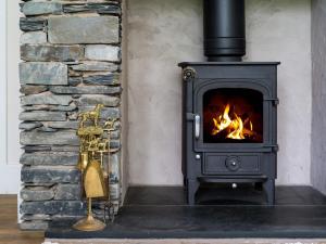 a stove with a fire in a room at Fellside Lodge in Windermere