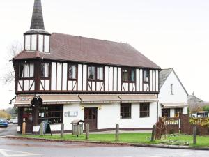 een zwart-wit gebouw met een toren bij The Bakery Restaurant with Rooms in Westerham