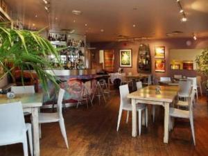 een restaurant met tafels en stoelen en een bar bij The Bakery Restaurant with Rooms in Westerham