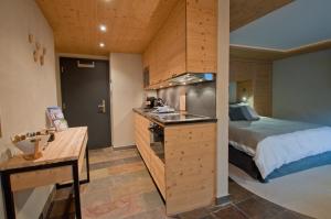 een slaapkamer met een bed en een keuken met een wastafel bij Twin Peak apartment at Nevada prime in Zermatt