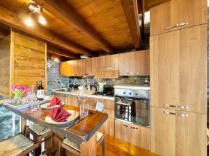 a kitchen with wooden cabinets and a table with red napkins at Casa Brenzio Rustico in Consiglio di Rumo