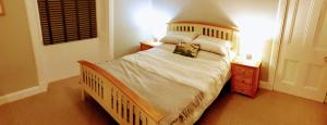 een slaapkamer met een groot bed met witte lakens en kussens bij Harbour Lights - Spectacular Sea Views in Crail