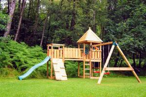 un parque infantil de madera con tobogán y estructura de juegos en Luxury woodland Alder Lodge en Killin