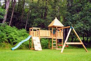 un parque infantil de madera con tobogán y estructura de juegos en Luxury woodland Alder Lodge, en Killin