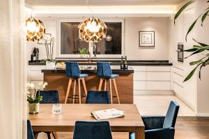 a kitchen with a wooden table and blue chairs at Schenna Chalet - Chalet Penthouse in Schenna