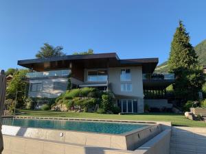 a house with a swimming pool in front of it at Schenna Chalet - Chalet Penthouse in Schenna