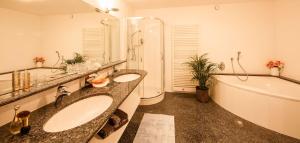 a bathroom with two sinks and a bath tub at Schenna Chalet - Chalet Oasis in Schenna +26 photos