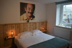 a bedroom with a bed with a portrait of a man at Luxury Spa Hotel - Francofolies in Spa