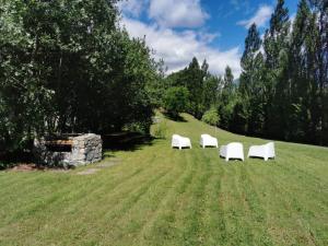 tres sillas blancas sentadas en medio de un campo en Derby Village, en Villaret