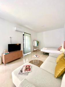ein Wohnzimmer mit einem Sofa und einem TV in der Unterkunft Apartamentos - Alameda in Ronda
