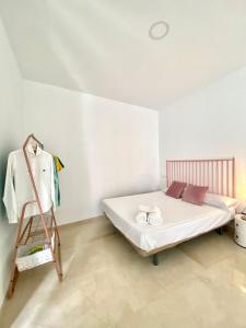 a bedroom with a bed and a clothes rack at Apartamentos - Alameda in Ronda