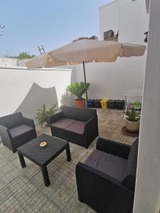 patio con divani, tavolo e ombrellone di Don Carlo Casa Vacenze a Campi Salentina
