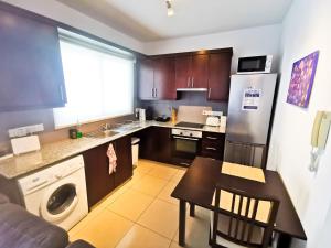 eine kleine Küche mit einem Tisch und einem Kühlschrank in der Unterkunft Promenade Breeze City Apartment in Larnaka