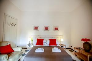 ein Schlafzimmer mit einem großen Bett mit roten Kissen in der Unterkunft Appartamento ellea resort in San Michele Salentino