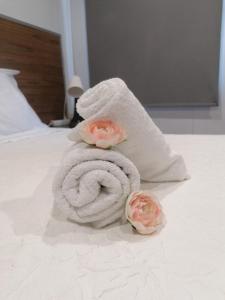 a towel with two roses on a bed at Historic House in Braga