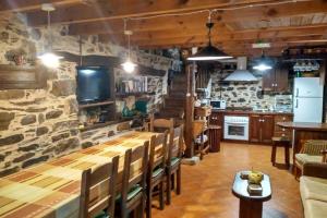 un restaurante con una larga mesa de madera y sillas en Casa da Penisquela, en O Barco de Valdeorras