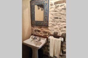 a bathroom with a sink and a mirror and towels at Casa da Penisquela in O Barco de Valdeorras