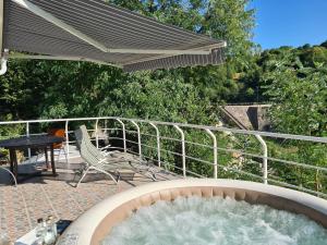 una bañera de hidromasaje en un patio con una silla y una mesa en Casa Bella, en Dognecea 10 fotos más