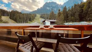 布希坦尼的住宿－Hrodberht Ski Apartment，阳台配有2把椅子和1张桌子,享有风景。