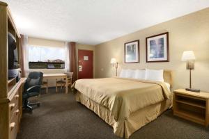 Habitación de hotel con cama y escritorio en Days Inn by Wyndham Oklahoma City Fairground, en Oklahoma City