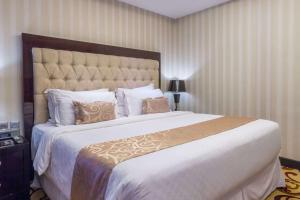 Un dormitorio con una cama grande con una gran colcha blanca en Wyndham Surabaya, en Surabaya