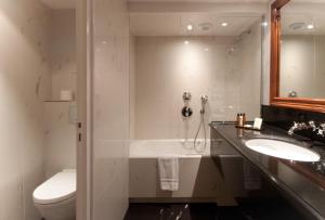 a bathroom with a tub and a sink and a toilet at Hotel Left Bank Saint Germain in Paris