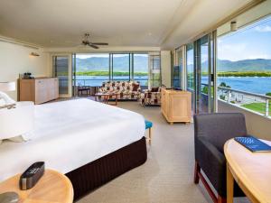 
a hotel room with a large bed and a large window at Pullman Reef Hotel Casino in Cairns
