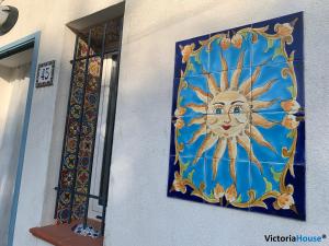 a painting of a sun on the side of a building at Victoria House Scopello in Scopello +113 photos