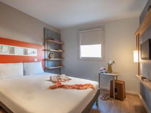 a bedroom with a large white bed and a window at ibis budget Nice Californie Lenval in Nice