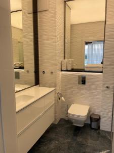 Baño blanco con aseo y lavamanos en Apartament Faltom Gdynia Yacht Park, en Gdynia