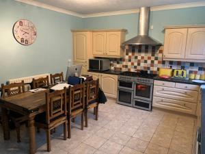 a kitchen with a table and a stove top oven at Home from Home 1 in Castleford