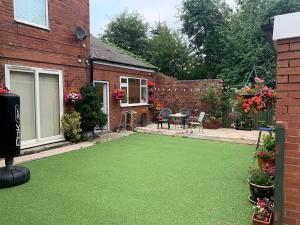 a backyard with a green lawn in front of a house at Home from Home 1 in Castleford
