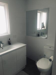 a bathroom with a toilet and a sink and a mirror at Beach House Getaway 1 in Smiths Beach
