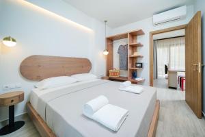 a bedroom with a large white bed with white pillows at Oikies Doreta in Chrysi Ammoudia