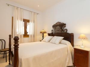 Un dormitorio con una cama grande con cabecero de madera. en Can peret, en Sa Pobla
