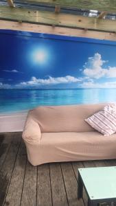 a couch in a room with a painting of the ocean at Beach House Getaway 1 in Smiths Beach