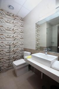 a bathroom with a sink and a toilet and a mirror at Genx Crescent Lucknow in Lucknow