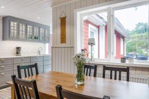 a kitchen with a wooden table with a vase of flowers on it at Large vacationhome with a modern design in Blankered