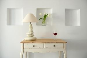 a table with a lamp and a glass of wine at Nefeli Sunset Studios in Pollonia