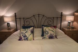 a bedroom with a bed with white sheets and pillows at Brampton Luxury Annexe Apartment in Huntingdon