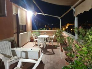 a patio with a table and chairs on a balcony at night at La terrazza di Anna in Sassari